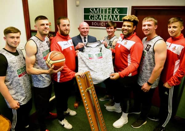Steven Horsley, partner at Smith and Graham solicitors, presents Hartlepool Heat basketball team players (left to right) Matty Thackery, Luke Thompson, Paul Robson, Micah Innes, Jimi Aramide, Liam Hay and Ellis Huntley with their new kit as they display their League 1 Championship trophy. Picture by FRANK REID
