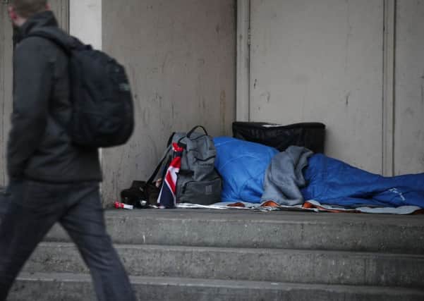 A person sleeping rough in a doorway.