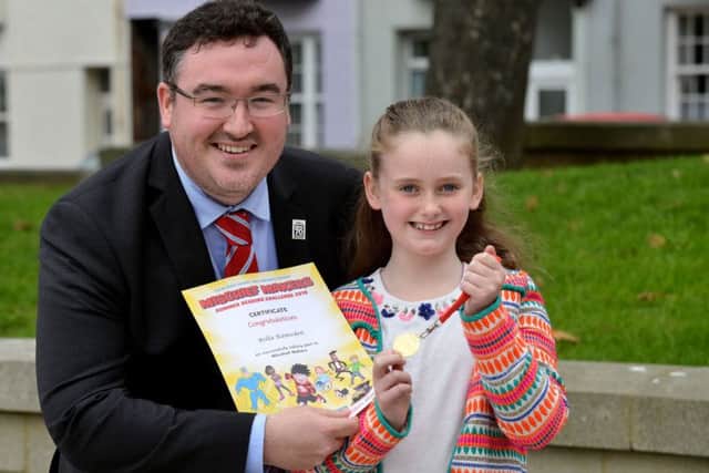 Hartlepool Borough councillor Michael McLaughlin presents a reading certificate and medal to young reader Bella Ramsden. Picture by FRANK REID