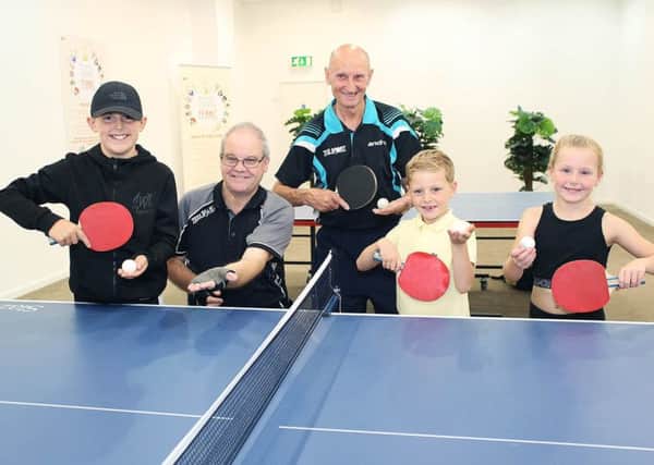 Table tennis players (from left to right), Travis Paul, Peter McIntosh, George Smurthwaite, and Lily Paul are ready for action as they post with coach Alun Hind