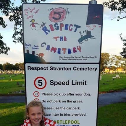 Hannah Dunning with her poster on a sign in Stranton Cemetery.