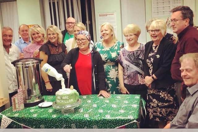 Ann cutting a cake at a coffee morning held by colleagues at Citizens Advice Hartlepool which raised Â£650 for Macmillan Cancer Support.