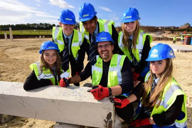 Dave Coplin signs the concrete pile for the new buildings at the High Tunstall College of Science with students (left to right) Maddy Wilson, Joseph Liddell, Ankusa Gupta, Alex Dickson and Holly Bentham.