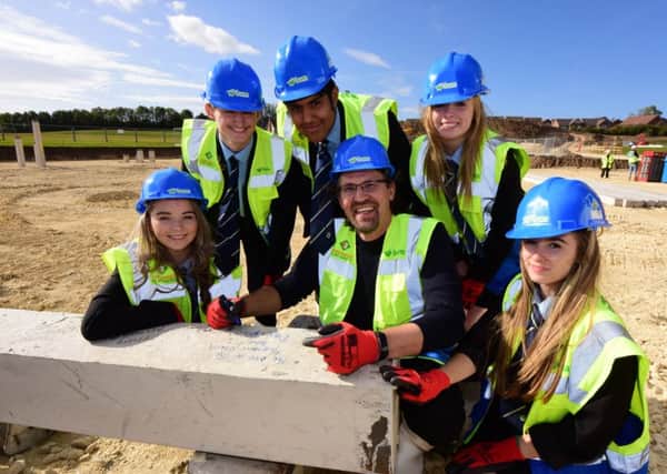Dave Coplin signs the concrete pile for the new buildings at the High Tunstall College of Science with students (left to right) Maddy Wilson, Joseph Liddell, Ankusa Gupta, Alex Dickson and Holly Bentham.