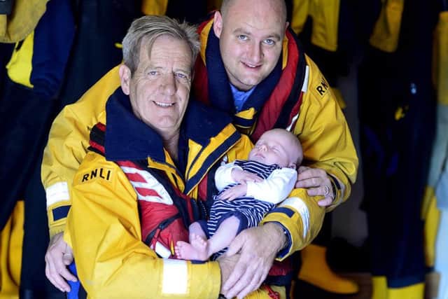 New dad Liam Dunnett and his own father Steve with Arthur in his arms. Photo by Tom Collins/RNLI.
