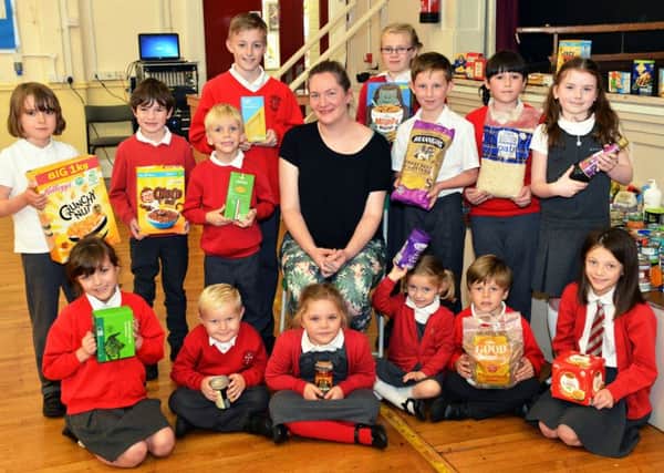 Abi Knowles Hartlepool foodbank co-ordinator is presented with items by pupils from Sacred Heart Primary school. Picture by FRANK REID