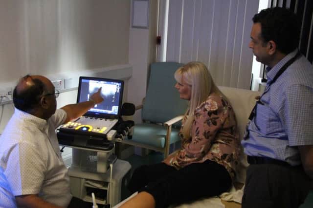 Dr Raju (left) performing an ultrasound on patient Denise Alderton, with assistance from Mr Limaye