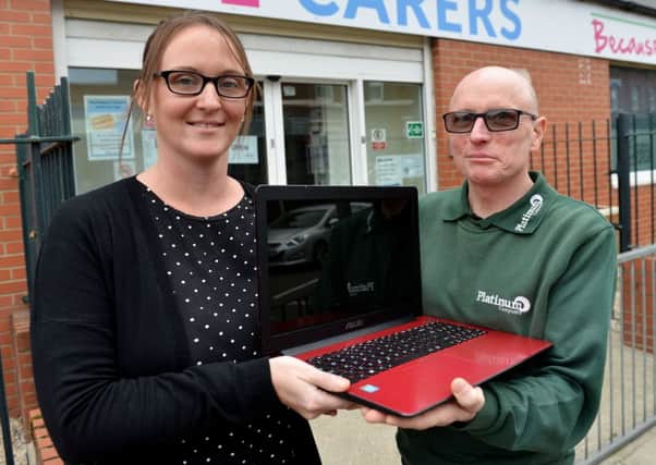 Christine Fewster, chief executive of Hartlepool Carers, is presented with the laptop by Mick Stafford from Platinum Computers.