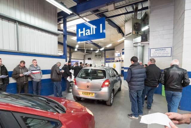 People assessing cars at Manheim