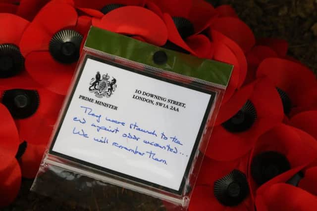 The message on a wreath that Prime Minister Theresa May placed at the grave George Ellison, the last British soldier to be killed before Armistice in 1918, at the St Symphorien Military Cemetery in Mons. PRESS ASSOCIATION Photo. Picture date: Friday November 9, 2018. See PA story MEMORIAL Armistice May. Photo credit: Gareth Fuller/PA Wire