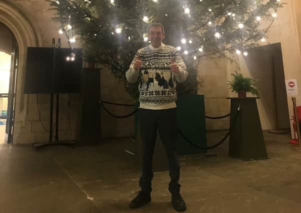Mike Hill in festive jumper under the Christmas tree.