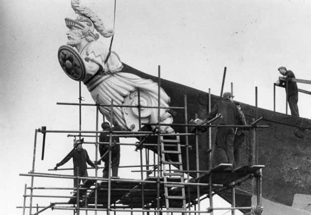 HMS Warrior's figurehead, a worthy addition to the restoration progress, is hoisted into position in 1985.