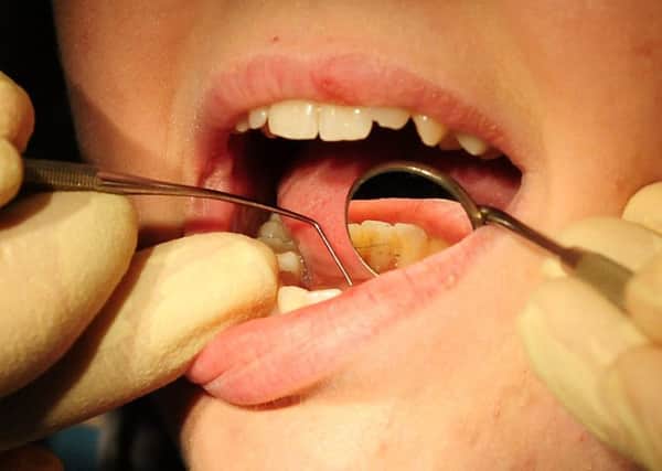 A dentist at work on a child's teeth. Picture by PA Archive/PA Images