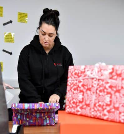 (Left to right) Gemma Lowery filling Christmas shoe boxes.