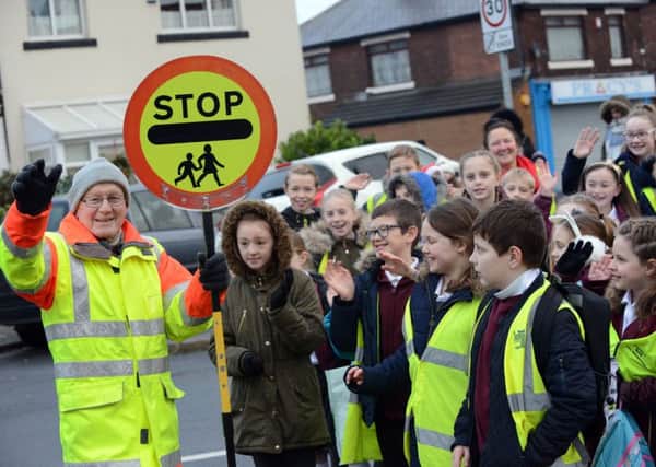 Lollipop man Geoff Chandler  on his last day before his retirement with St Cuthbert's RC Primary School children