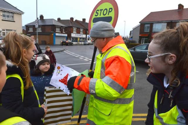 Lollipop man Geoff Chandler receives presents from St Cuthbert's RC Primary School children on his last day before his retirement with