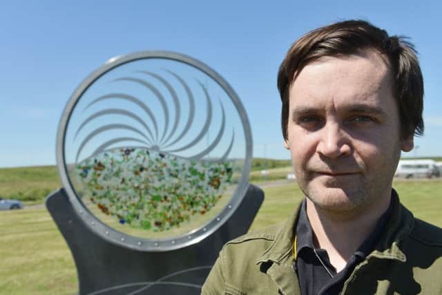 Standing at his Waves sculpture at Seaton Reach is artist Stuart Langley. Picture by FRANK REID