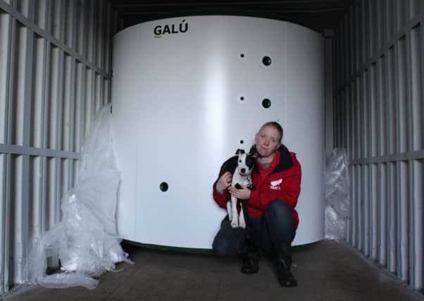 Animal Welfare assistant Hannah Critchlow with 16-week-old staffie cross pup Vera in front of their new 4,500-litre hot water tank.