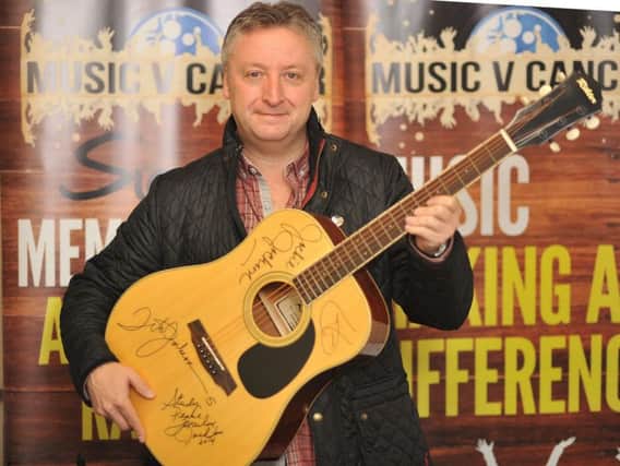 Tony Larkin pictured with the guitar signed by The Jacksons.