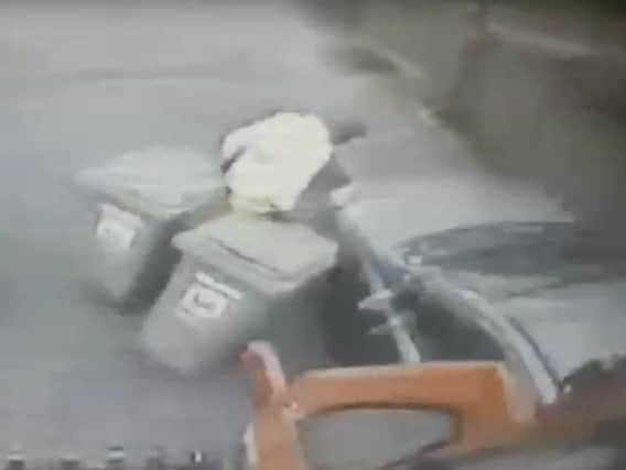 A car narrowly avoids bin collectors in CCTV footage released by Hartlepool Borough Council.