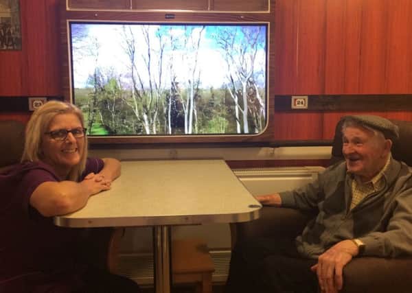 Wynards Woods care home resident Ron Murray (right) and care assistant Janet Robinson by the train carriage feature to help people with dementia.