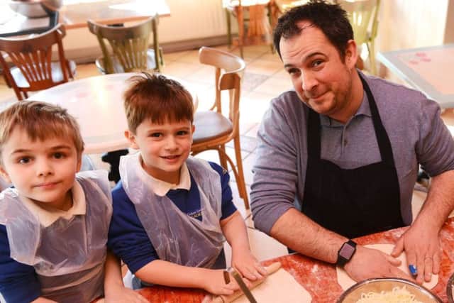 Portofino chef Noel Stamp giving a helping hand to Eldon Grove Primary School pupil and son Nate (centre) and his fellow pupil Korey Thompson.