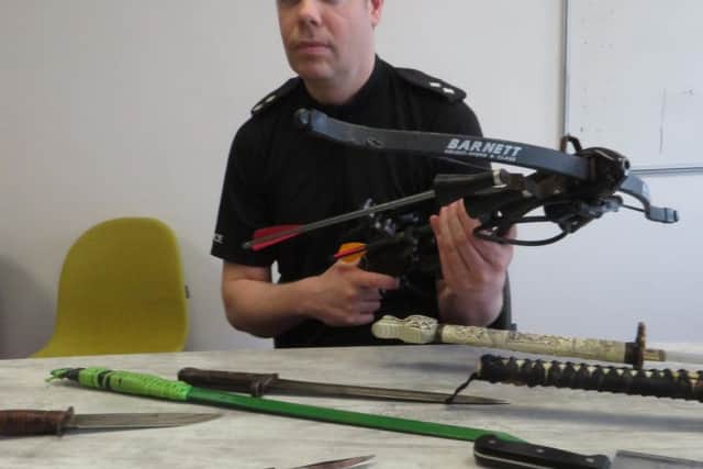 Insp Jon Hagen with some of the weapons handed in  including Samurai swords, a crossbow, meat cleaver, hunting knives and knives which people have made their own modifications to.