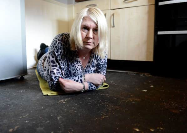 Nicola Hewitt inspecting the exposed kitchen floor prior to the new layer of concrete being laid. Picture by FRANK REID