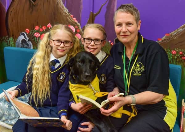 Val Yuill of Therapy Dogs Nationwide and her dog Annie at Hart Primary School, reading with  twins Isabella and Rebecca Weston.
