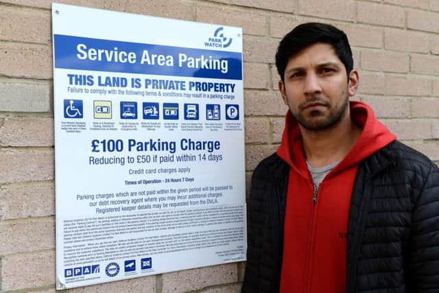 Umar Akhtar next to a service area parking notice, Castle Dene Shopping Centre Peterlee. Picture by FRANK REID