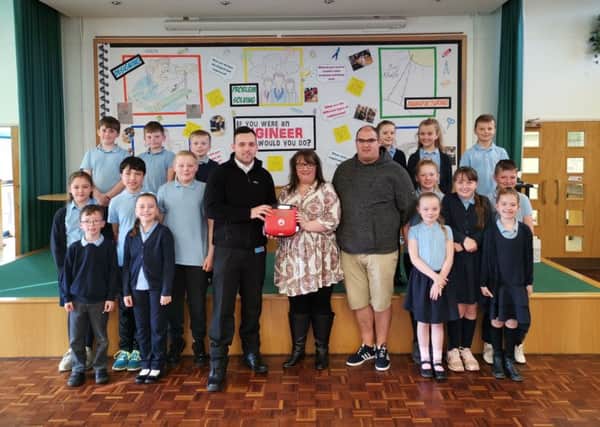 Adam Goodwin and Paul Foster of Defibs4Hartlepool with staff and pupils at Kingsley Primary School.