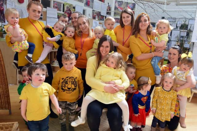 Ava Oram, 2 (middle) with mother Sam Mitchell surrounded by fundraising staff and pupils