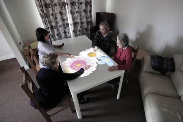 Debbie Halliwell and residents Audrey Hamilton, Eleanor Winspear and Mary Altringhma play a game on the interactive dementia table. Photograph: Stuart Boulton