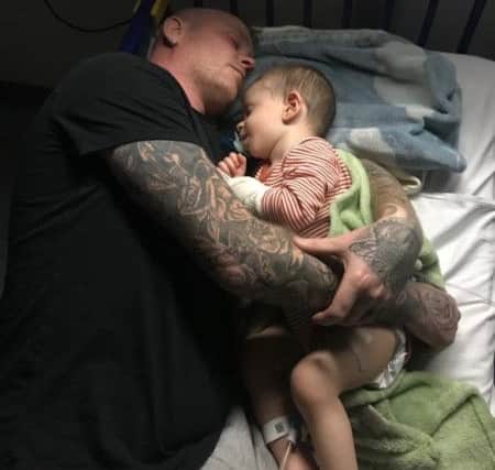 Teddie McCallum is cradled in his hospital bed.
