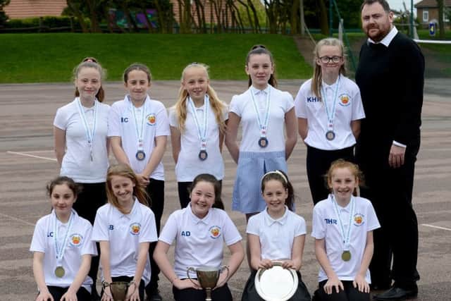Easington Primary School girls football team (rear left to right) Lily-Mae Box, Daisy Clarke, Demi-Leigh Tapping, Josie Fenwick and Keisha Hall-Reay, coach Michael Shaw,(front left to right) Lainee Cope, Lily Bliss, Abi Ditchburn, Niamh Walker and Tyra Hall-Reay with their trophies.