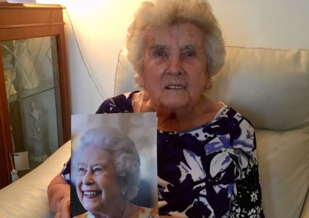 Minnie Nichol celebrating her 100th birthday with a card from Her Majesty the Queen.