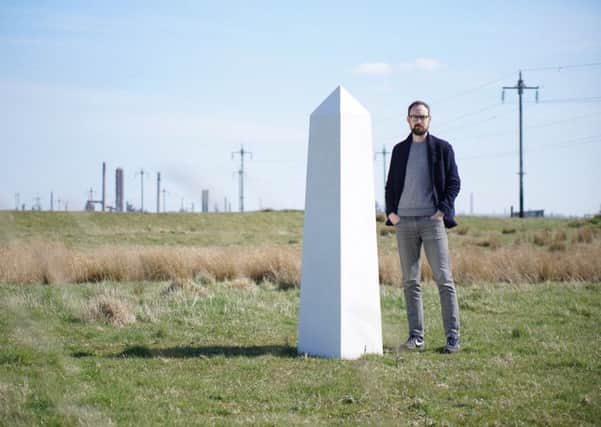 Artist and poet Thomas Pearson with one of the 12 white obelisks at RSPB Saltholme.