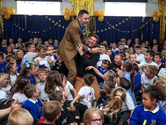 Dave McPartlin and David Walliams with some of the children at Flakefleet Primary School. Picture: PA.