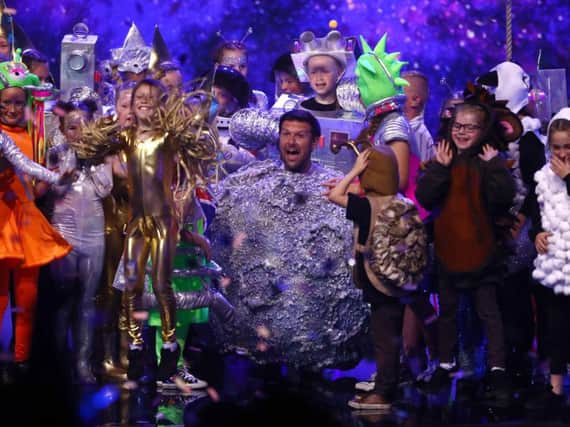 Dave McPartlin on stage with his Flakefleet Primary School pupils in the final of Britain's Got Talent. Dymond/Thames/Syco/Shutterstock.