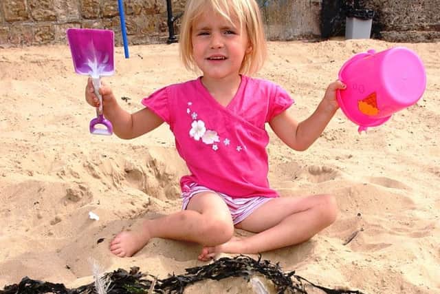 Three year old Megan Skeet with her sandcastle design on the Fish Sands. Picture by DAN PHILLIPS. D18282