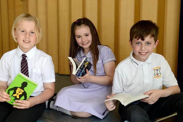 St. Teresas Primary School pupils (left to right) Lucas Beddow, Cherry Hutchinson and Ewan McWilliam settle to read their books by Dam Smith.  Picture by FRANK REID