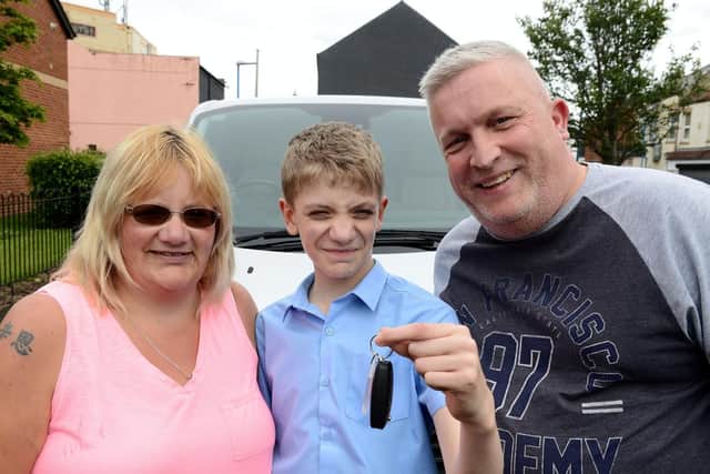Joshua Dawson (centre) with mum Michaela Dawson and Kevin Hill from Bring Back a Smile holding the keys for the minibus. Picture by FRANK REID