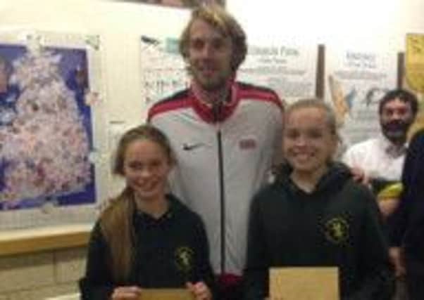 Harriers Eve Dixon and Lucy Surtees are presented with their awards by British long jump champion Chris Tomlinson