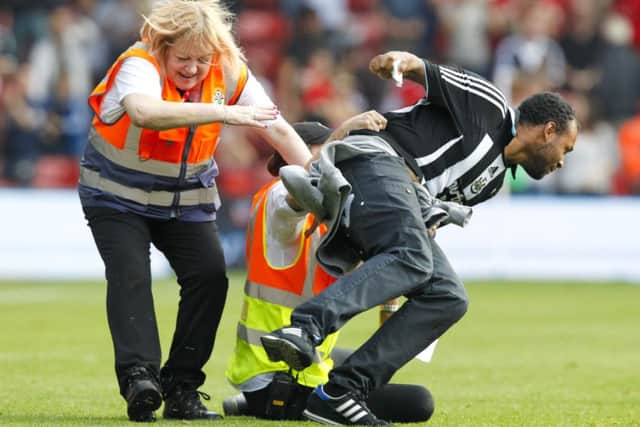 A Newcastle United fan runs onto the pitch at the end of the Barclays Premier League match at St Mary's