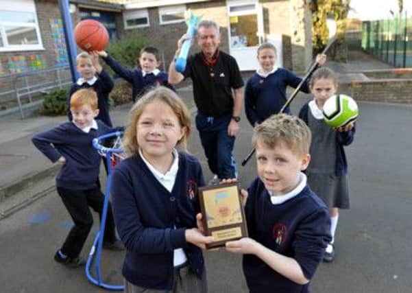 Easington Church of England Primary school Puils Annna Quarmbyand Ronnie Hutton and the Sports Mark award as Sports teacher John Robertson and fellow pupils (left to right) Dylan Craggs, Joshua Simpson, Thomas Ashcroft, Katy Stobbs and Ava Keegan look on