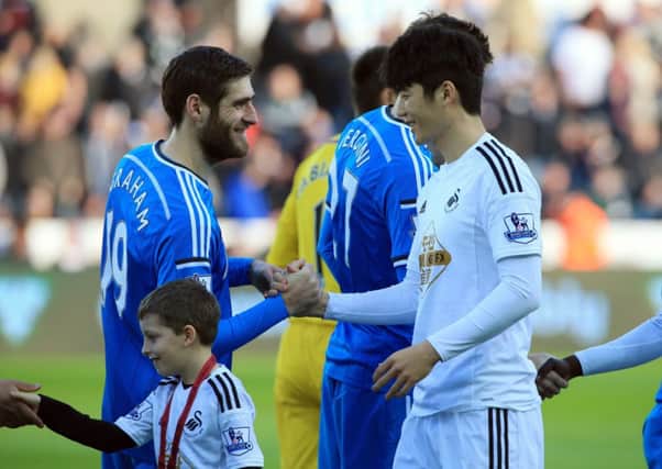 Sunderland's Danny Graham and Swansea City's Ki Sung-Yueng greet each other before the Barclays Premier League match at The Liberty Stadium