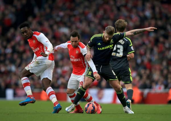 Arsenal's Danny Welbeck (left and Santi Cazorla battle for the ball with Middlesbrough's Adam Clayton (right) during the FA Cup Fifth Round match at the Emirates Stadium