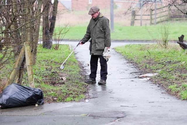 Mitch Wilson, who lives behind the A179, is picking up litter to put in his own bin.