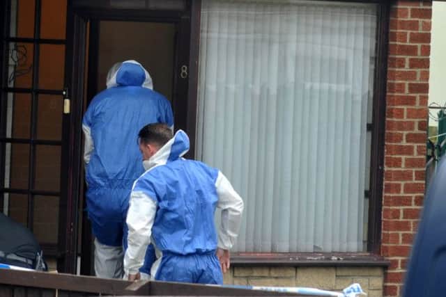 Police officers enter a house at Whin Meadows.