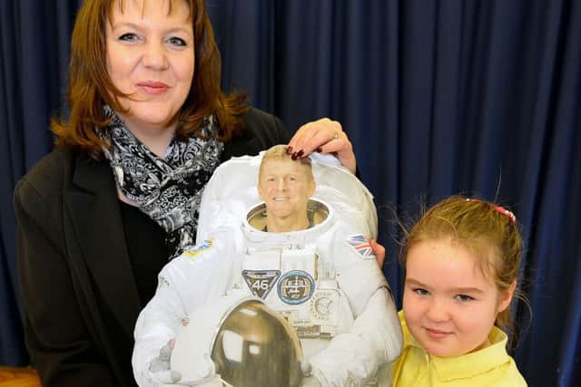 Headteacher Sue Sharpe and Year 5 pupil Chloe Gale holding a photograph of British astronaut Tim Peake.